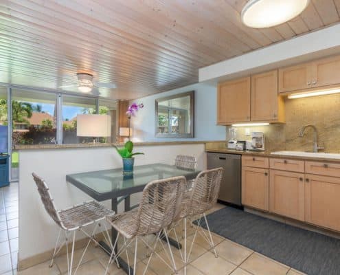 Dining table, chairs, kitchen area.