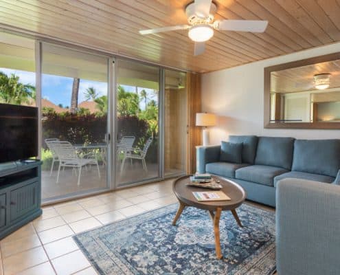 Living room with a couch, table, lamp, and patio.