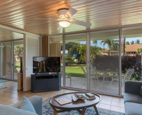 Living room with a table, TV, and patio.